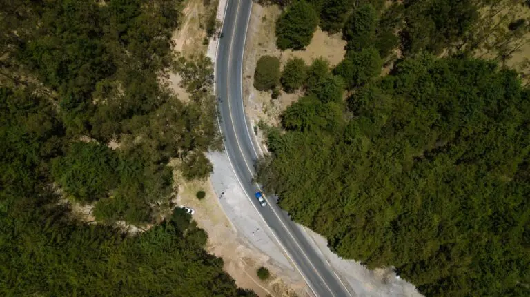 Aerial photo of asphalt road running through forest