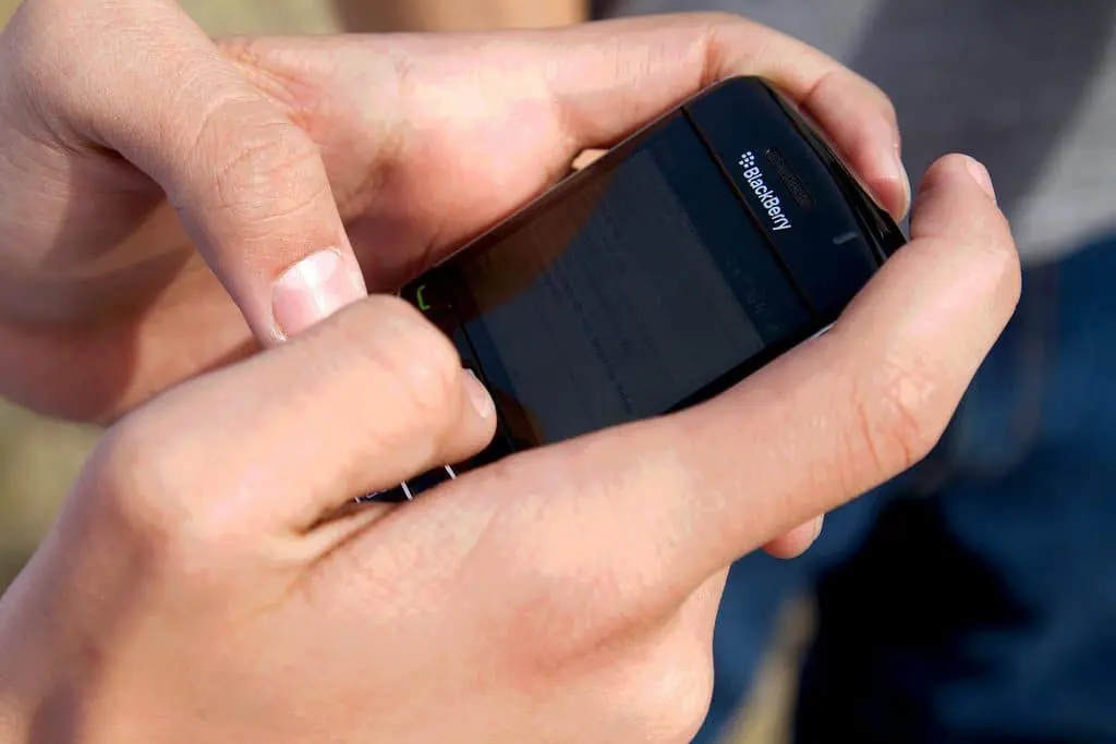 Cómo reclamar ante la cnc Una persona interactuando con su teléfono celular.