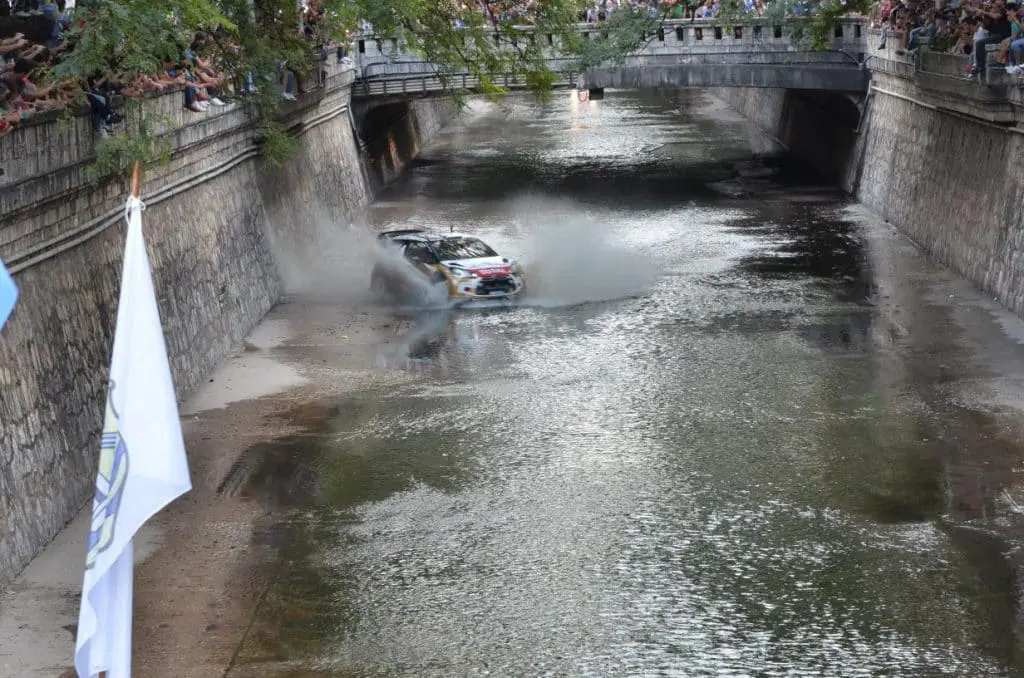 En la ciudad de córdoba, un automóvil participa en el rally mundial mientras avanza por un río.