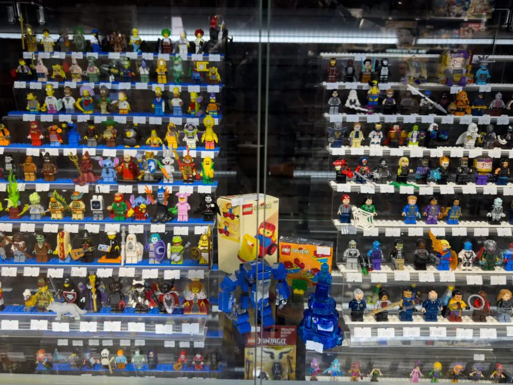 ¿qué buscan los coleccionistas al evaluar una nueva adquisición? 2 Exhibición de minifiguras lego raras y sets vintage en vitrina de colección, incluyendo cajas originales lego system.