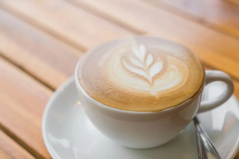 Taza de café con leche preparada con cafetera
