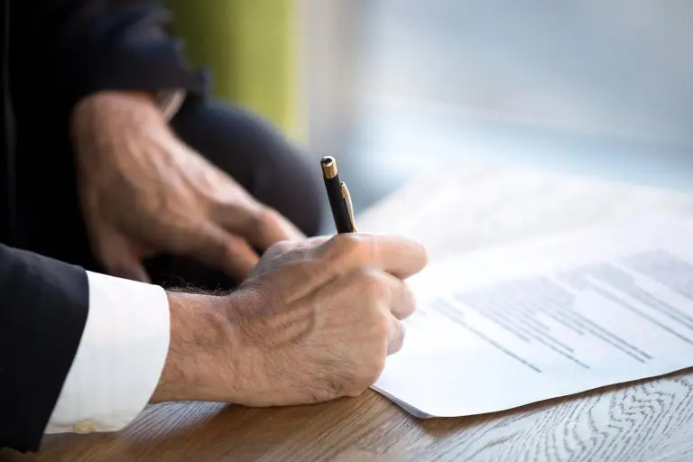 Persona firmando un formulario en papel sobre un escritorio, como en el trámite del certificado de domicilio en córdoba