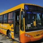 Precio del boleto de colectivo en córdoba 3 Un colectivo amarillo y naranja estacionado en un estacionamiento.