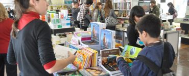 Visitantes de la Feria del Libro Córdoba 2016 hojeando libros en una librería.