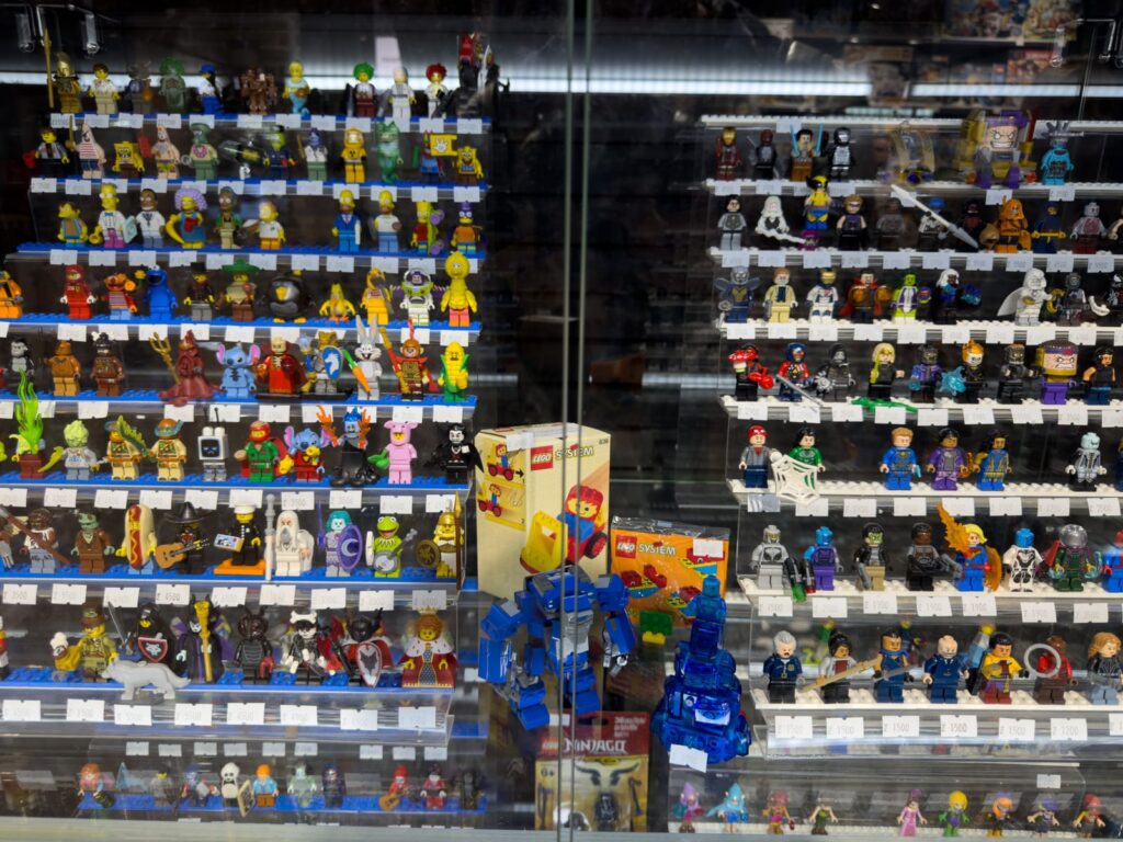 ¿qué buscan los coleccionistas al evaluar una nueva adquisición? 2 Exhibición de minifiguras lego raras y sets vintage en vitrina de colección, incluyendo cajas originales lego system.