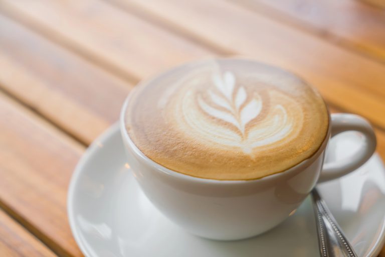 Taza de café con leche preparada con cafetera