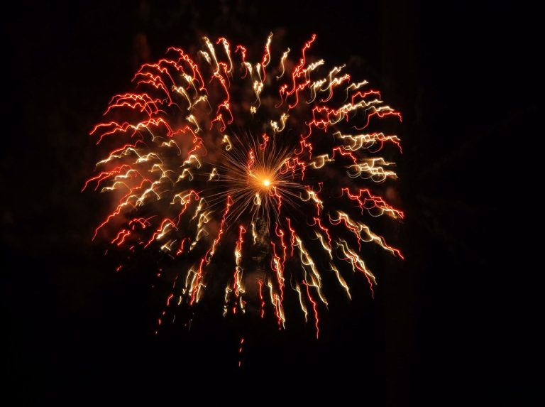 Fuegos artificiales rojos y dorados en el cielo de noche